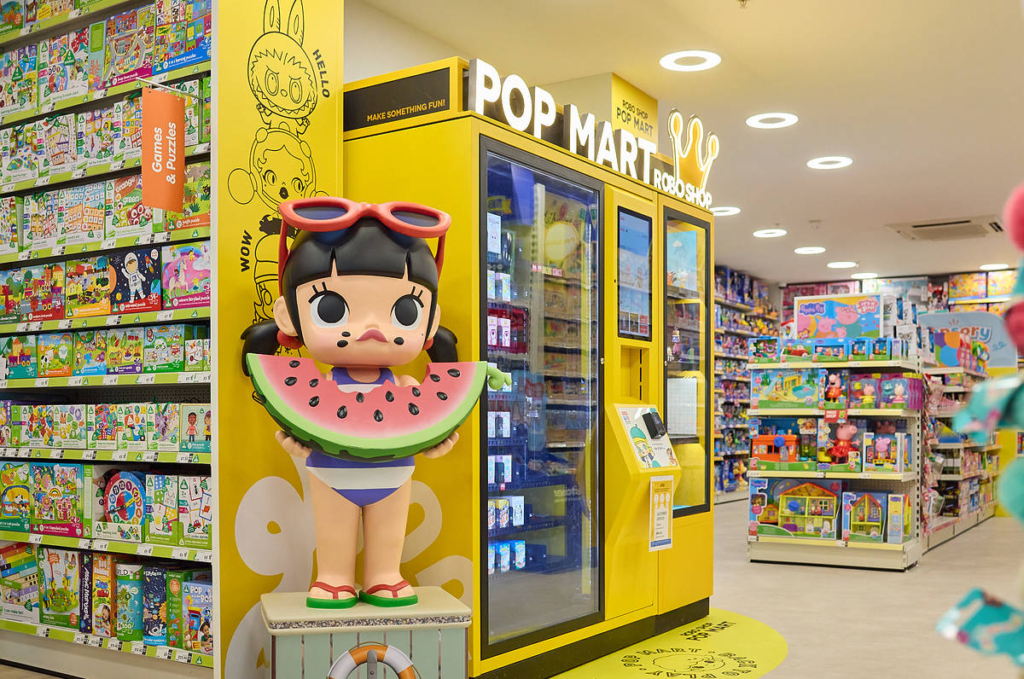 An automated Pop Mart Robo Shop vending machine stocked with blind box art toys in a high-traffic hallway.