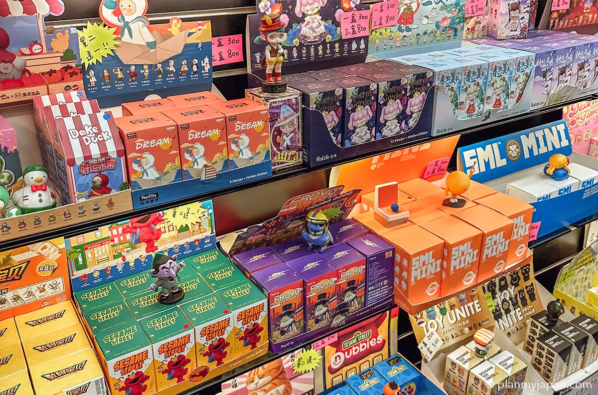 A colorful display of blind box collectibles from brands like ToyCity, Rolife, and FML MINI, featuring Sesame Street and other designer toy characters.