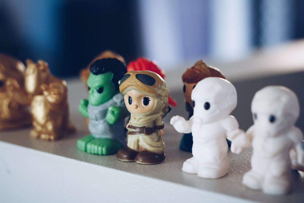 A shelf of small blind box figures, chibi-style characters in soft focus.