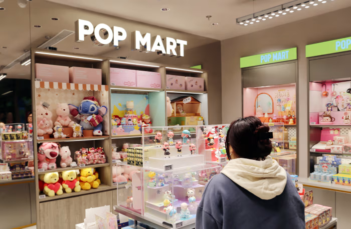A POP MART store filled with collectible figures, blind boxes, and plush toys from popular character series.